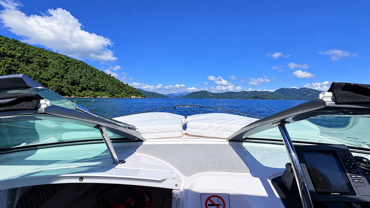 Vista da proa da Infinito, com estofados brancos e o mar de Paraty à frente