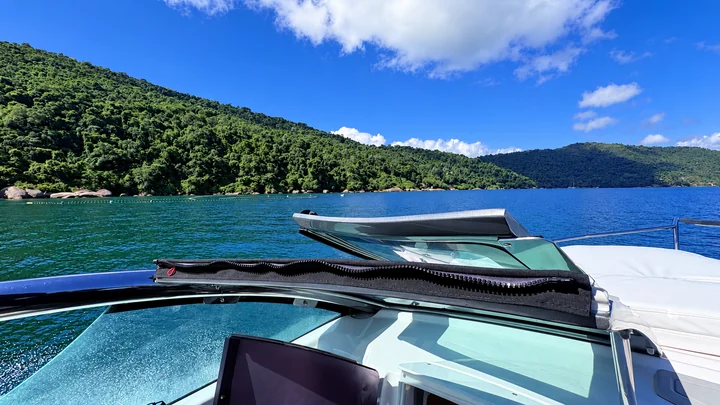 Mar azul e montanhas cobertas de mata vistos a bordo da lancha
